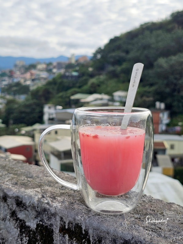 Gelovery草莓優格膠原蛋白飲在透明的杯子裡-側面照-天臺風景背景