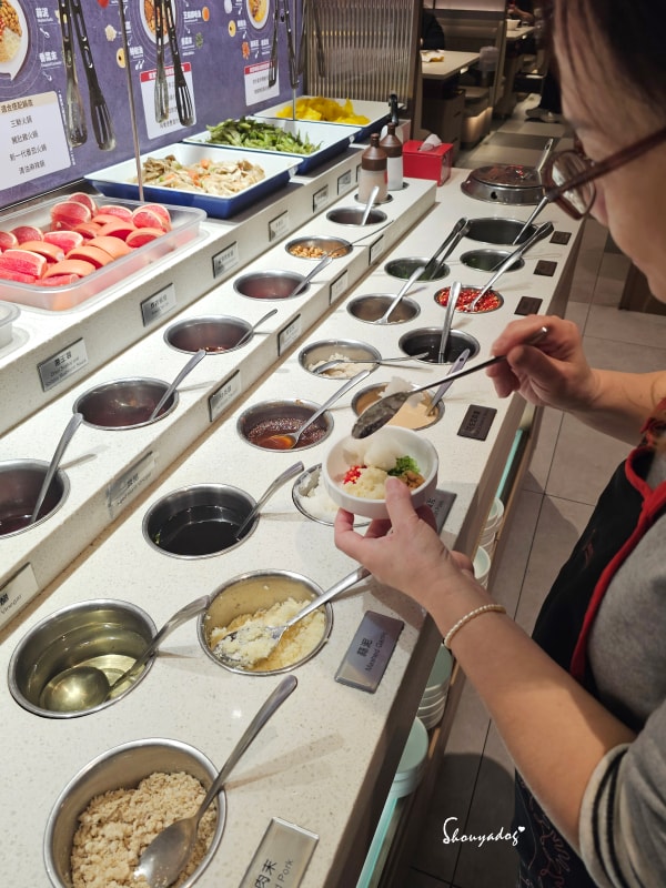 台北食記|海底撈火鍋信義微風南山店:傳承台灣一號店精神!三月兩老慶生大禮包、川劇變臉、會跳動的蛙?初體驗驚喜全紀錄 - 第10張圖 海底撈信義微風南山店-門市外觀-台北捷運市政府站美食-一號店傳承-裝醬料中