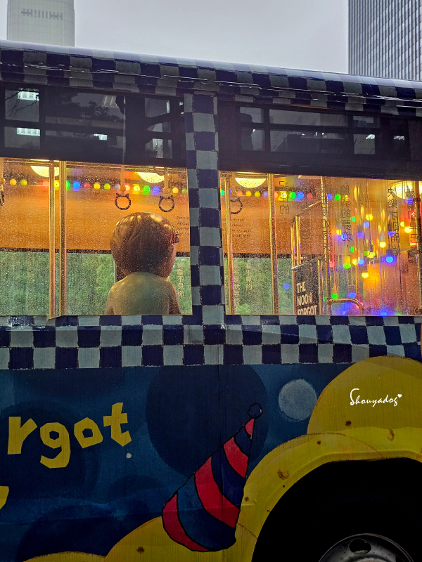 信義區打卡景點-幾米月亮公車小男孩在車裡的背影搭配雨景氛圍感拉滿